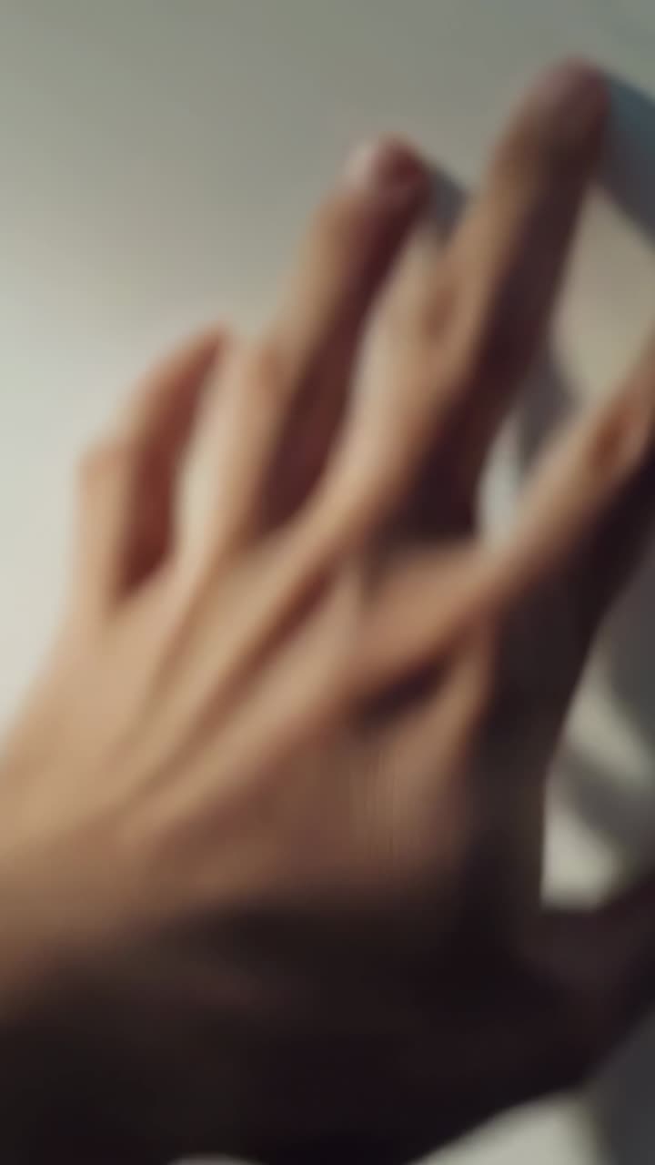 Sliding single adult hand rotating and flattening across pale smooth surface, showing wrist hair
