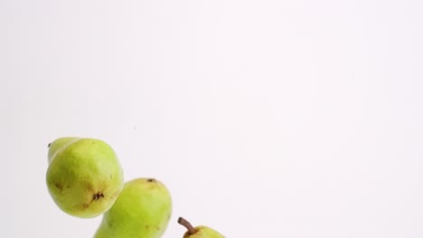 Whole-pears-falling-and-bouncing-in-slow-motion-on-white-studio-backdrop-in-4k