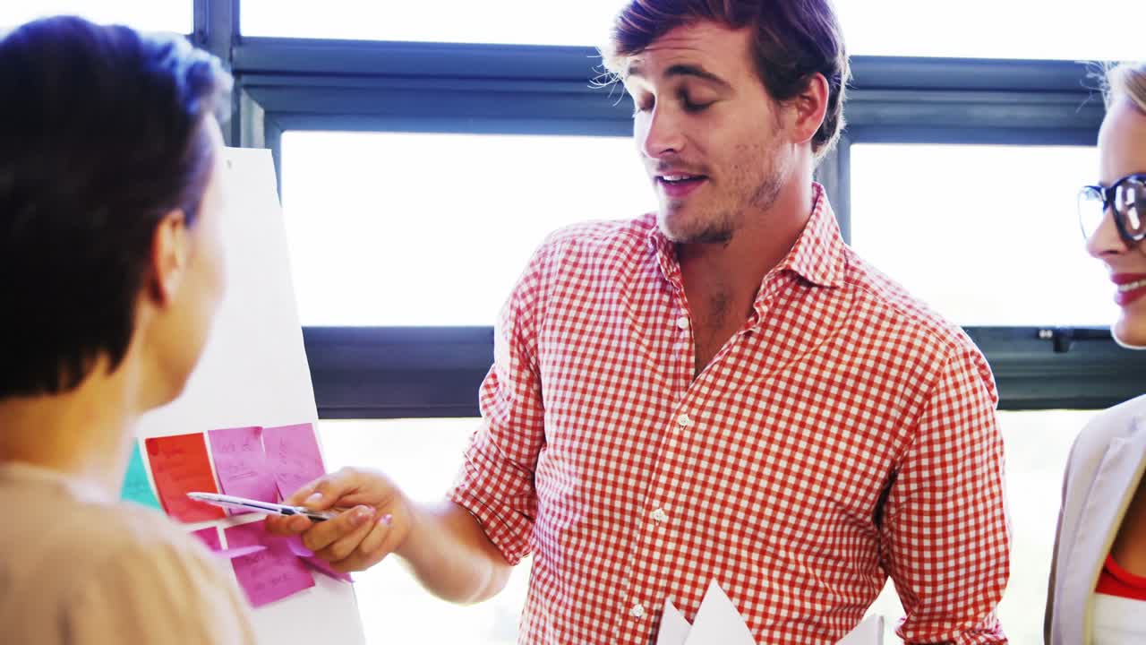 ejecutivos discutiendo sobre la pizarra blanca