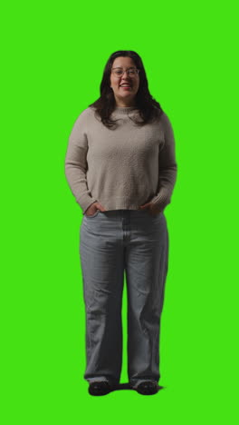 Vertical-Video-Full-Length-Portrait-Shot-Of-Smiling-Casually-Dressed-Young-Woman-Standing-Against-Green-Screen-2