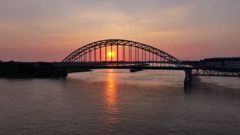 orange sun rising above the river noord and the hendrik ido ambacht bridge