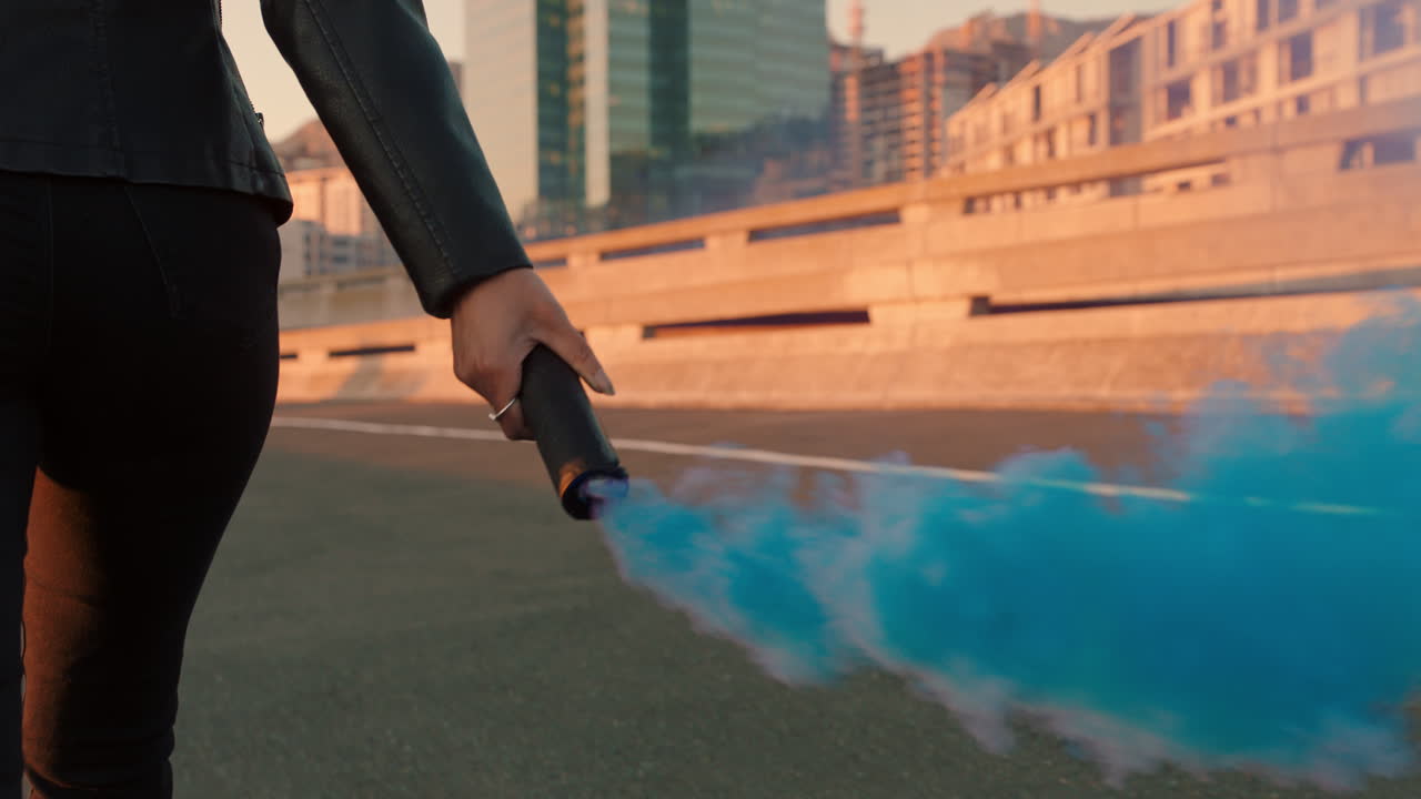 태양이 뜨면 도시 거리를  ⁇ 고 있는 연기 수류탄을 들고 있는 자신감 있는 여성 반항적인 여성 활동가 시위