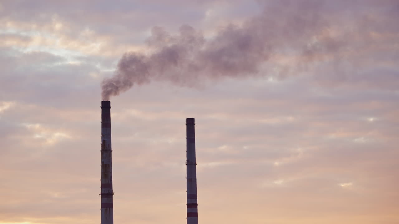 i camini alti degli impianti industriali fumano sullo sfondo della natura e del fiume. i camini sporchi delle fabbriche soffiano enormi fumi nell'aria. l'avvelenamento ambientale da parte dell'industria chimica.