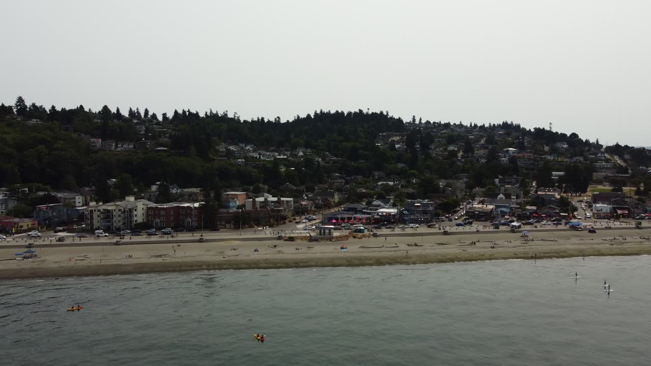 toma de drones de personas disfrutando de la playa en el suburbio de alki en seattle en un día lleno de humo.