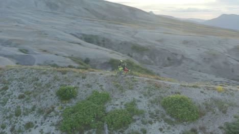 two mountainbikers standing on mountain trail ridge at foothills of mount st