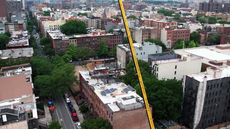 Flying-around-a-crane-at-a-urban-construction-area-in-NYC,-USA---Aerial-view