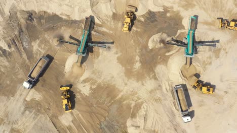 aerial view, machinery working at clay quarry, heavy loaders, large trucks, bulldozers, excavators, sand quarry, mining, truck takes raw materials from the quarry, large clay warehouse