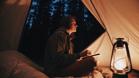 a person enjoying a peaceful night in a tent with a lantern