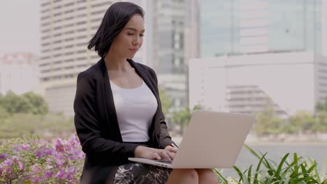 businesswoman working on laptop outdoors