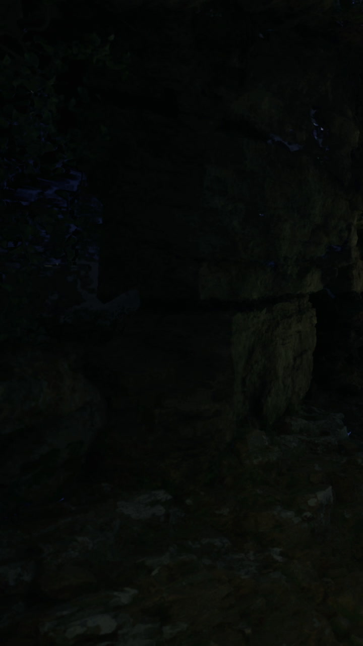 Exploring a rocky cave during nighttime