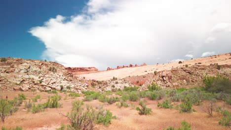 super wide static shot of the desert landscape with famous delicate arch in the background at arches national park, utah