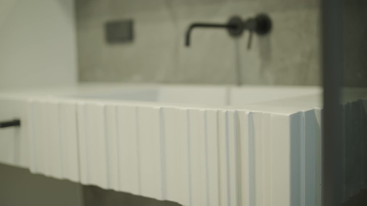 Moderne hvid tekstureret vask med sort armatur i minimalistisk badeværelse