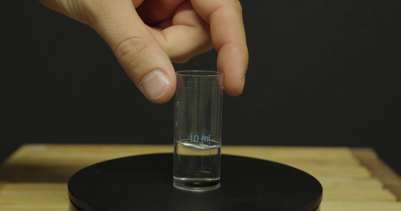 Performing a water hardness test using a drop test kit. Ideal for water quality, limescale, laboratory, and home testing concepts.