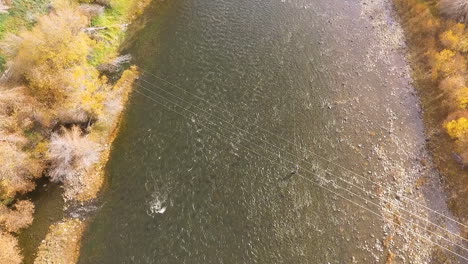 overhead shot of fly fishing river running under few power lines, fall, twin bridges montana