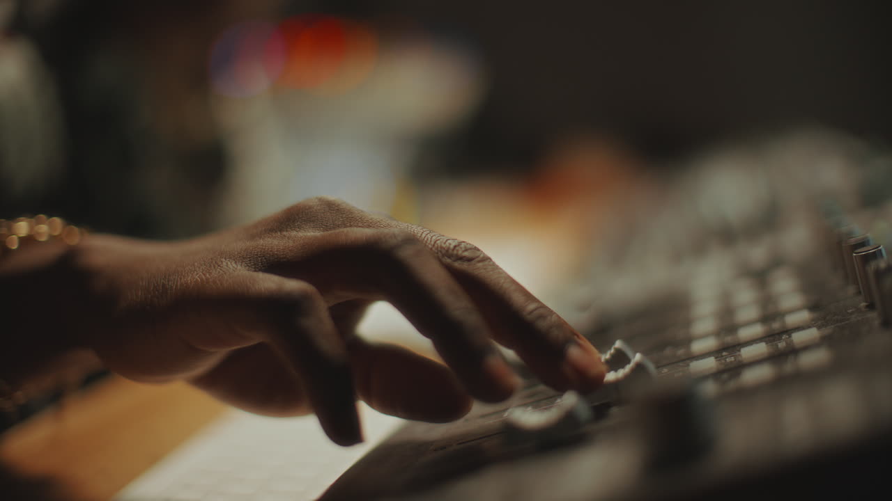 Close-Up of Hand of Sound Engineer Adjusting Faders on Audio Mixer