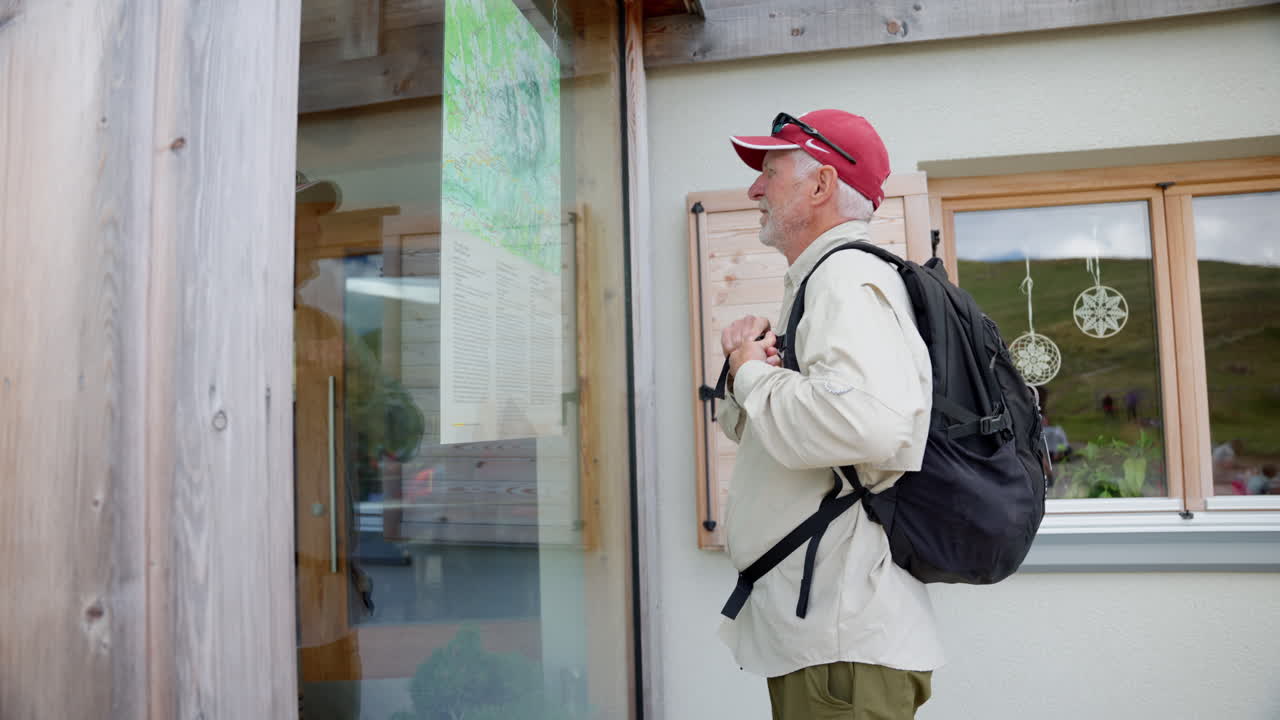 un turista mayor se está preparando para embarcarse en su viaje, revisando casualmente la guía que habían colgado en la pared como un mapa