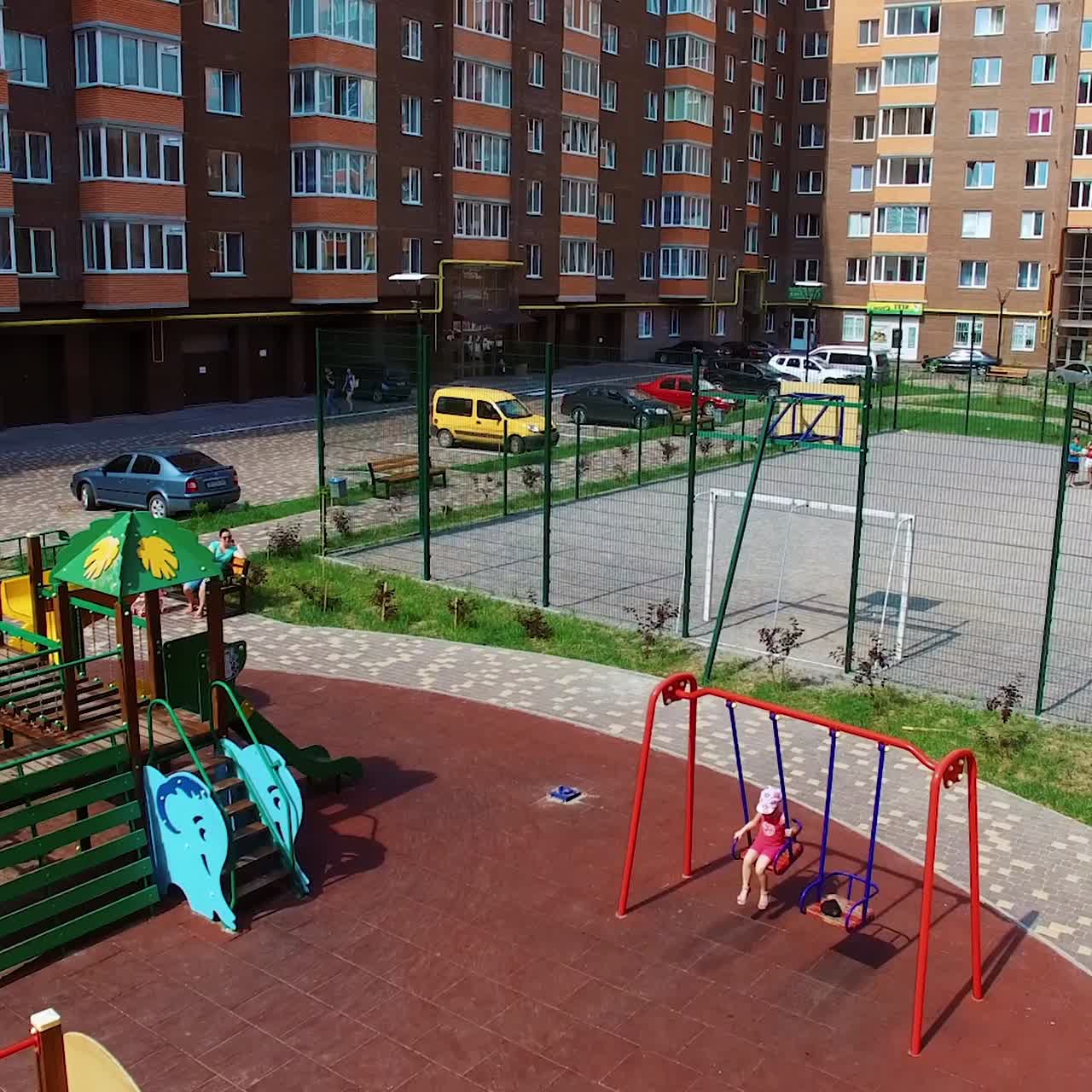Modern apartment buildings in an urban place. Comfortable children playgrounds and car parking near residential buildings in the new district.
