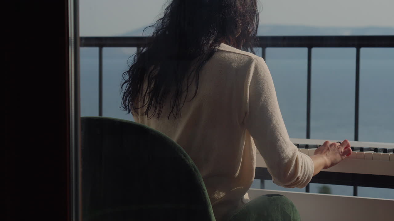 Woman Playing Piano on Balcony with Ocean View