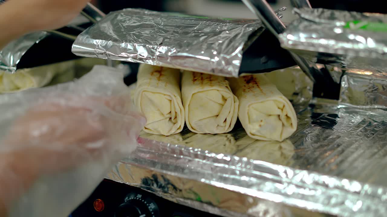 요리사는 그릴 위에 요리된 샤워마를 따뜻하게 합니다.