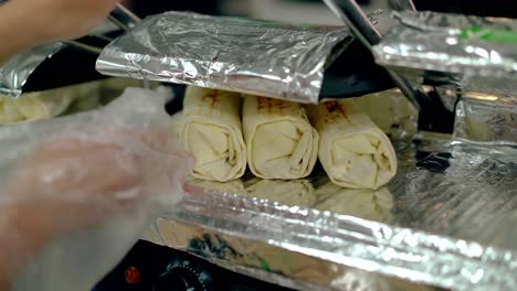 el cocinero calienta la shawarma cocida en la parrilla