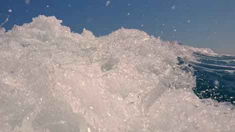 low angle perspective of water splash on sea surface behind speedboat