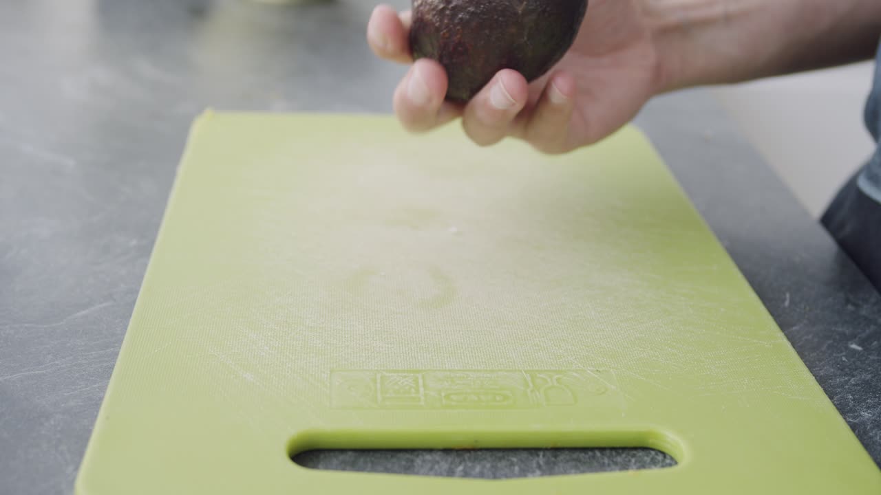 녹색 커팅 보드에 아보카도를 자르는 정적 샷