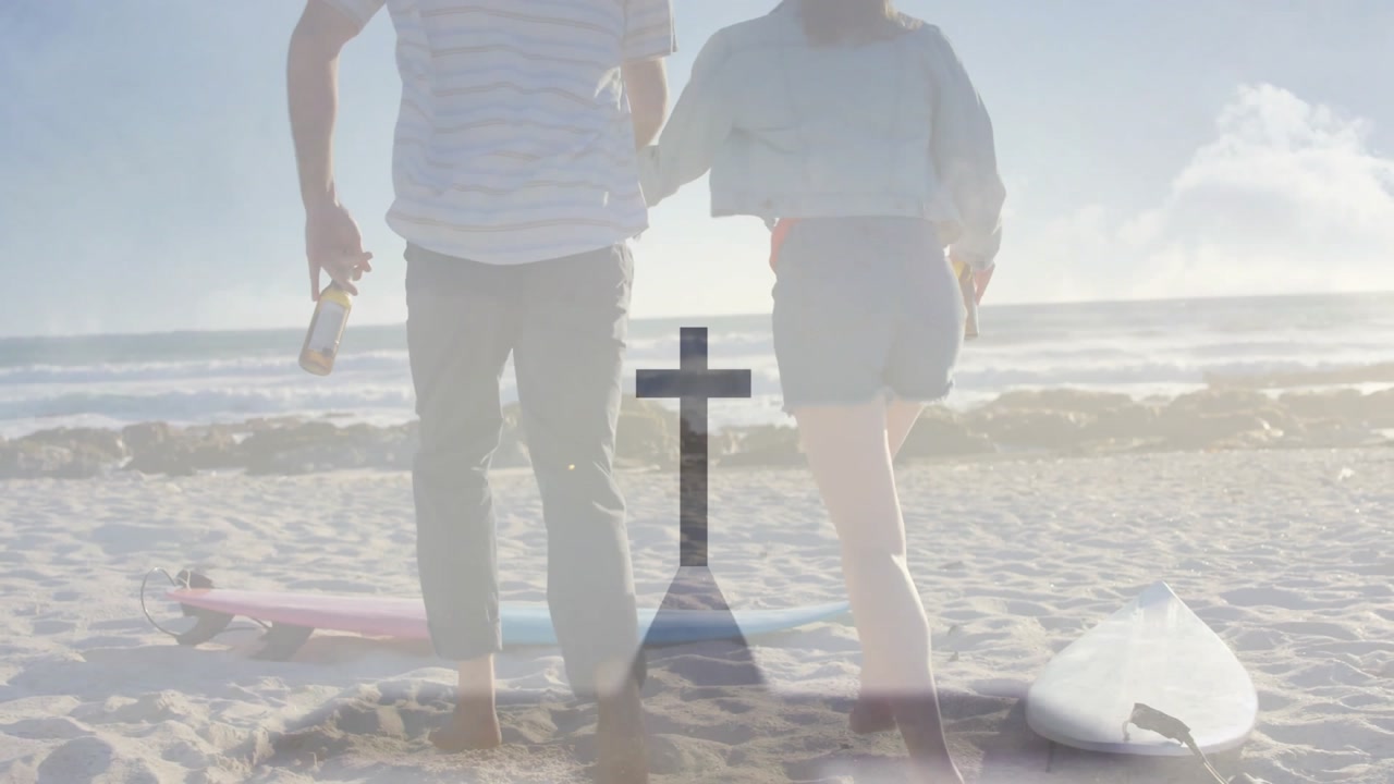 Travel couple holding bottles and glancing, walking beach past surfboards then running toward ocean