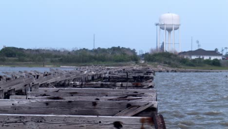 Slo-Mo:-Un-Muelle-De-Madera-Con-Una-Torre-De-Agua-Detrás