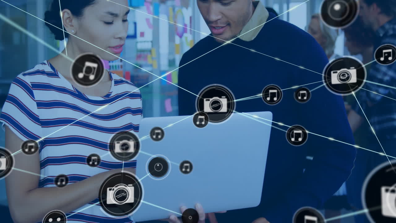 Animation of network of connections with icons over diverse colleagues discussing work in office