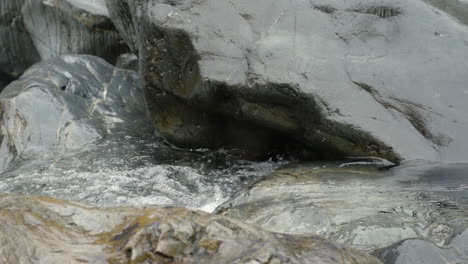 slow motion water flowing over rocks in shallow stream