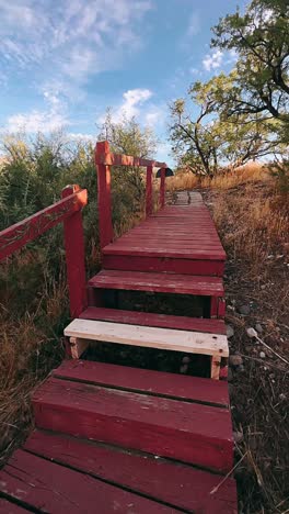 red wooden pathway through the countryside