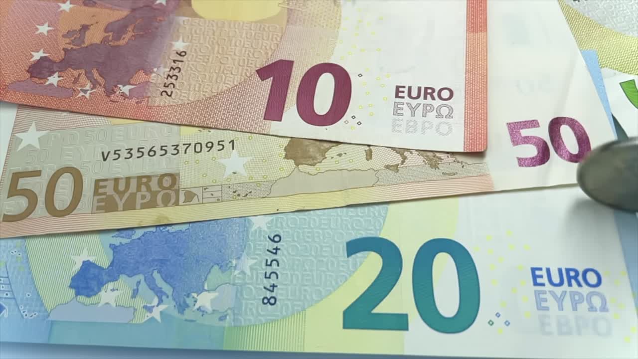 금속 러시아 루블 동전이 슬로우 모션으로 유로 화폐 위에 회전하고 있습니다.