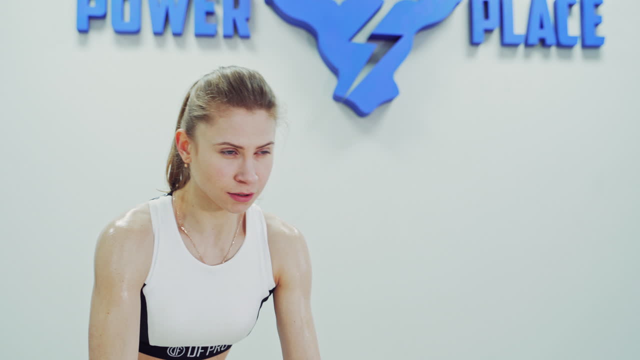 Girl doing exercises with sports equipment. Strong muscular woman working out with battle ropes