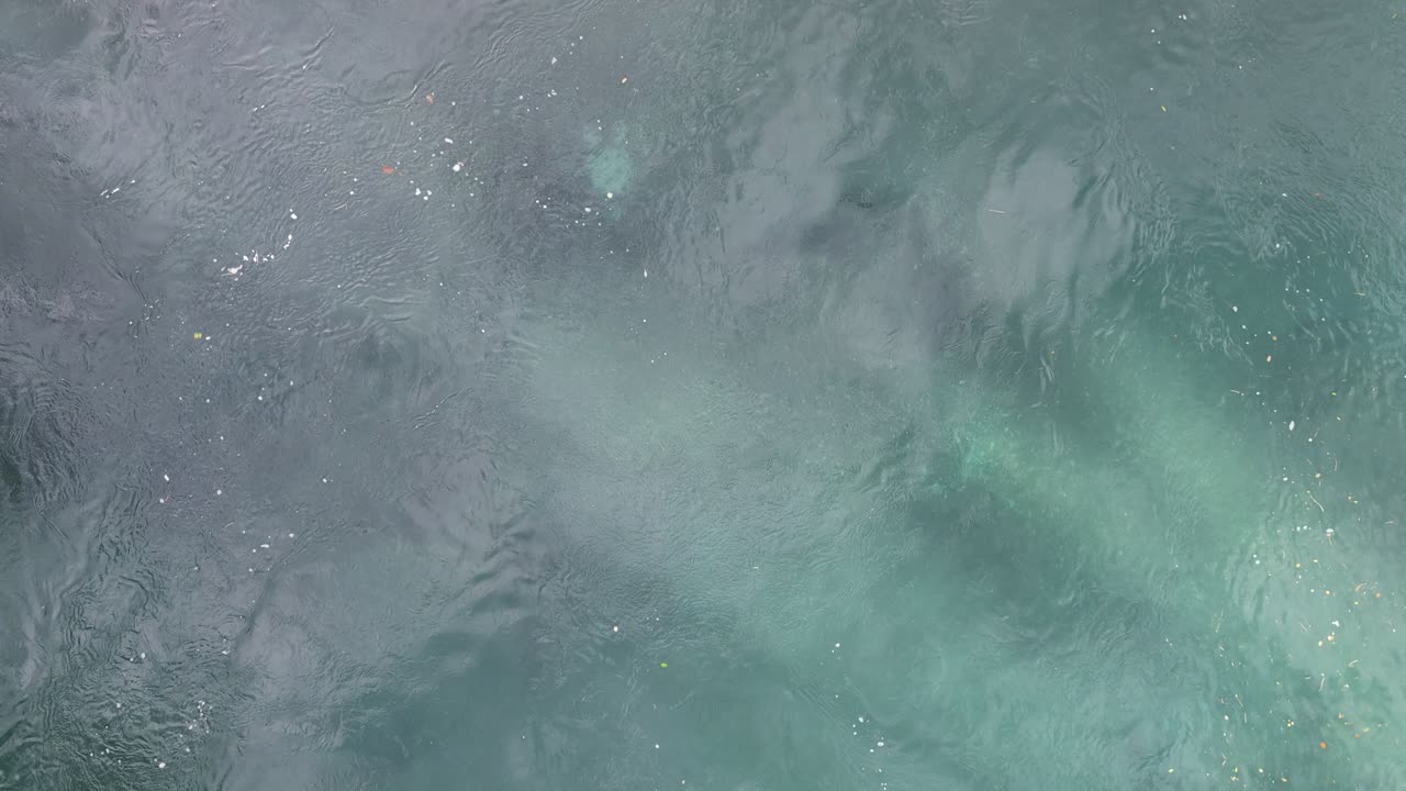 Abstract close-up view with water ripples and mineral deposits, creating textured turquoise blue-green surface