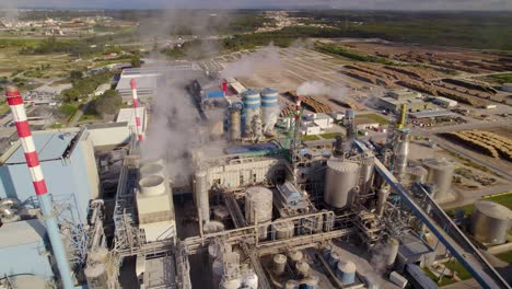 Aerial-orbit-shot-of-a-big-industrial-plant-on-a-sunny-day---a-lot-of-smoke-comes-out-of-the-chimneys