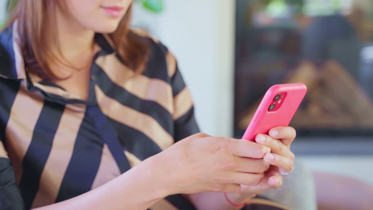 분홍색 스마트폰을 사용하는 여성