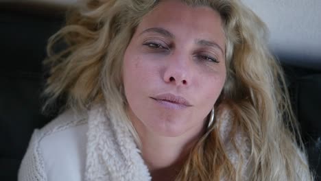 close-up of a sick woman resting as she briefly opens her eyes