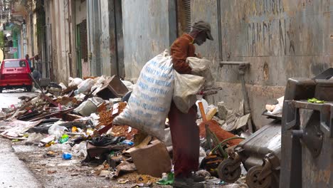 a man collects garbage along the streets of havana cuba