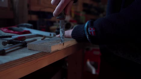 The Man is Using a Knife to Carve the Edge of a Wooden Plank Needed for the DIY Hot Tub - Close Up