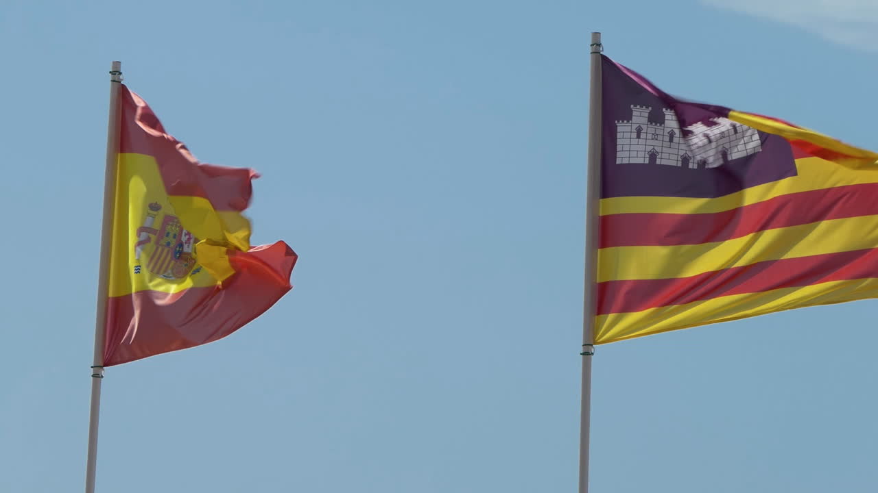 Spagna e Isole Baleari, una comunità autonoma in Spagna, bandiere che sventolano insieme al vento contro un cielo blu