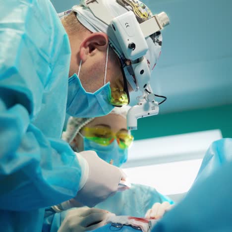 plastic surgery. medical procedure to a patient in clinic. professional surgeon in medical uniform performing an operation together with a nurse. close-up.