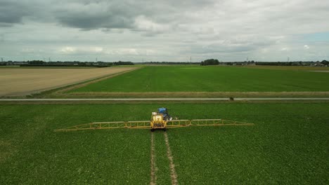 flying behind a tractor with trailed sprayer follows the tracks in a field and turns to the right