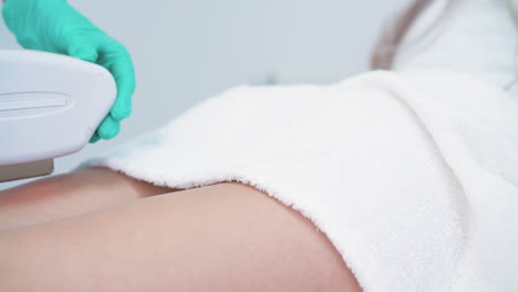 woman-in-white-bathrobe-undergoes-laser-epilation-procedure