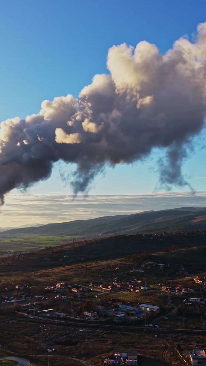 Durante el día, humo saliendo de una chimenea en una zona rural