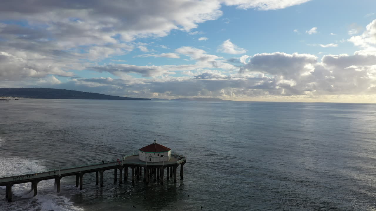 해질녘 캘리포니아 맨해튼 해변에 있는 부두의 회전 드론 보기