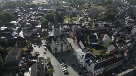 top-down view of a european village square with a prominent old church at the center, surrounded by homes.