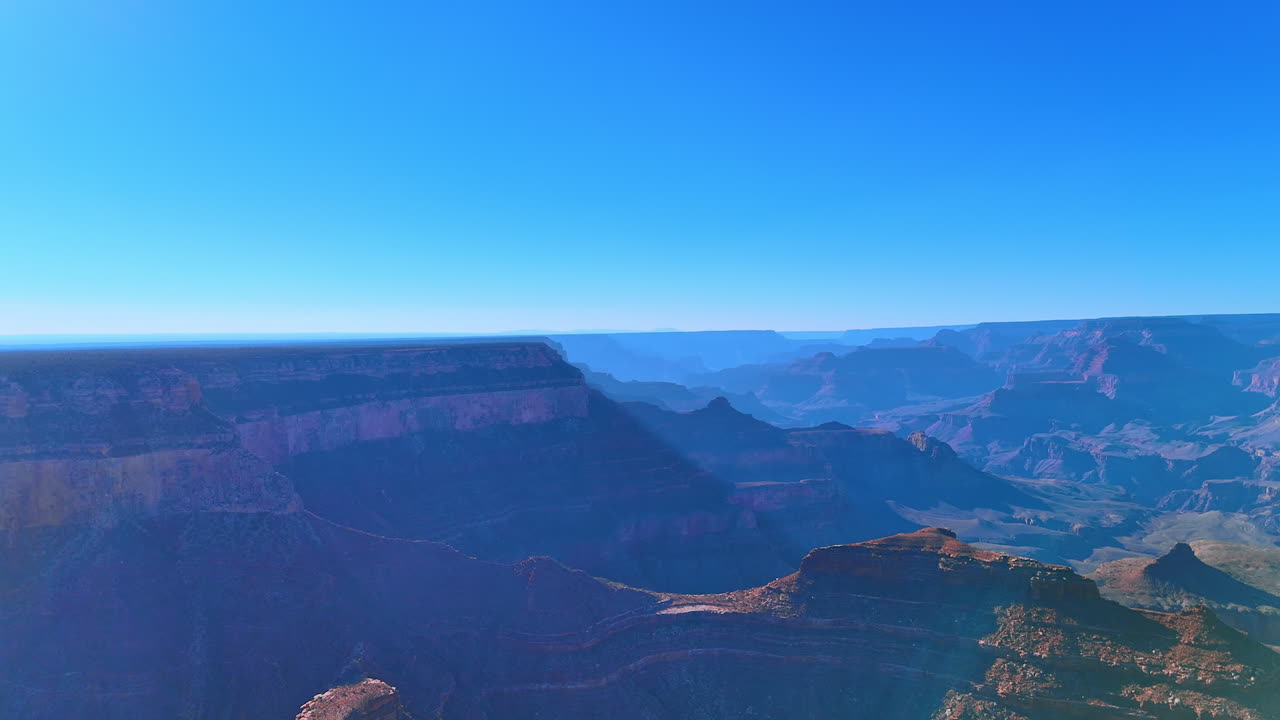 Grand Canyon cliffs under sun. Sunlit canyon walls showcase natural rock colors and depth