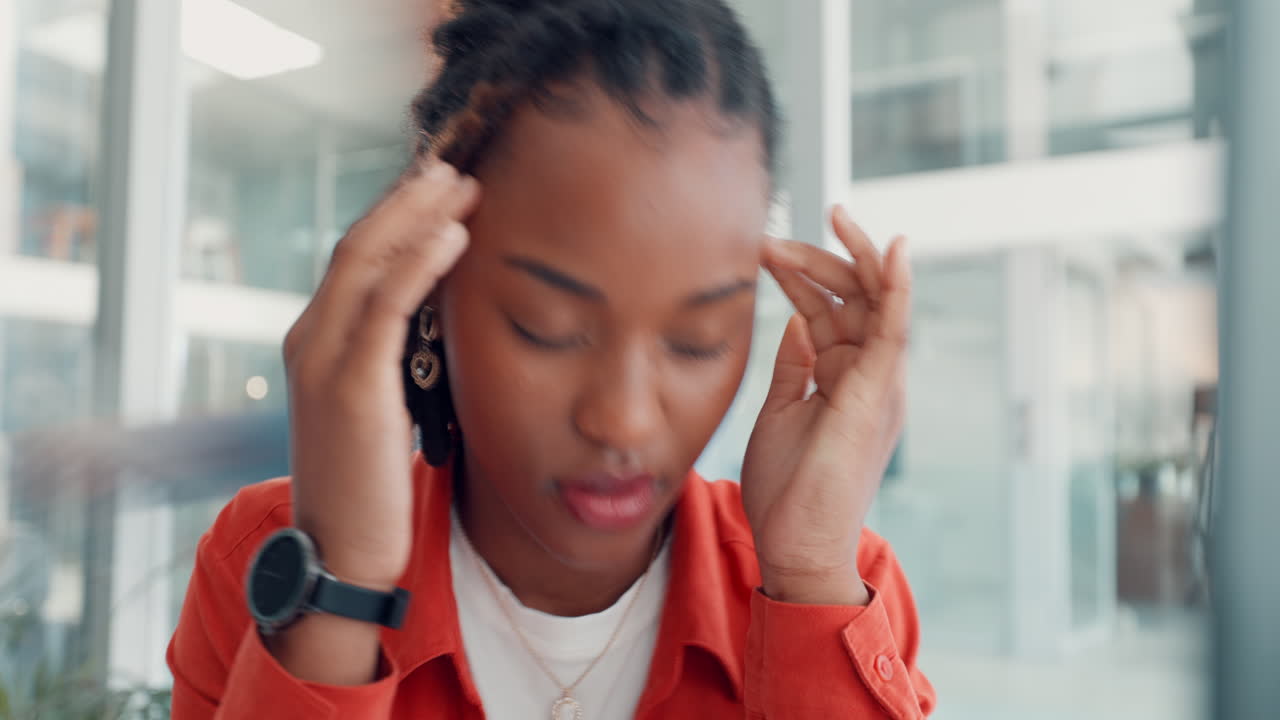 Woman experiencing headache and stress in the office