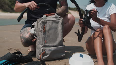 couple taking goggles out from backpack