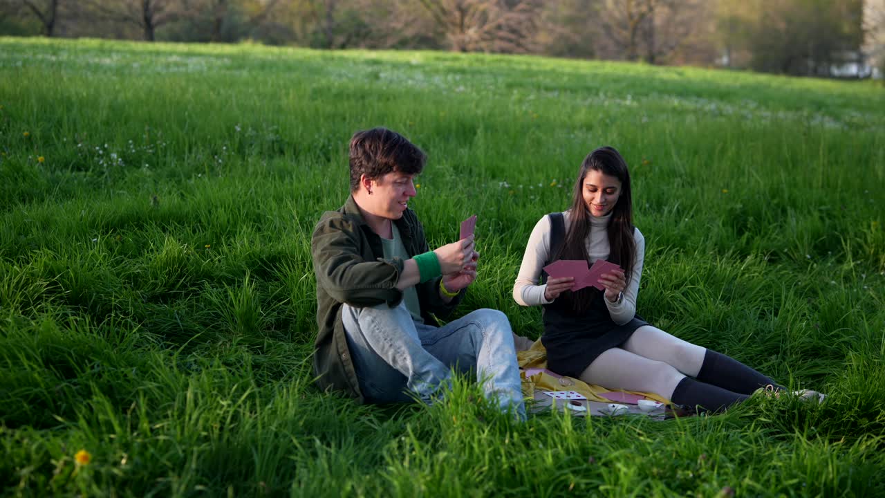 Couple Playing Cards in a Park